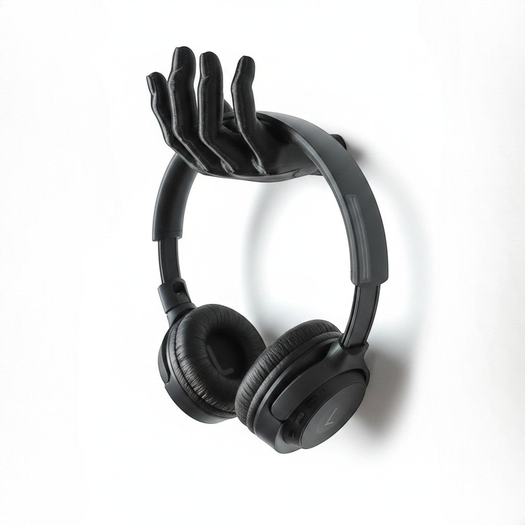 Black 3D printed hand-shaped headphone stand by Magicland 3D, mounted on a white wall.