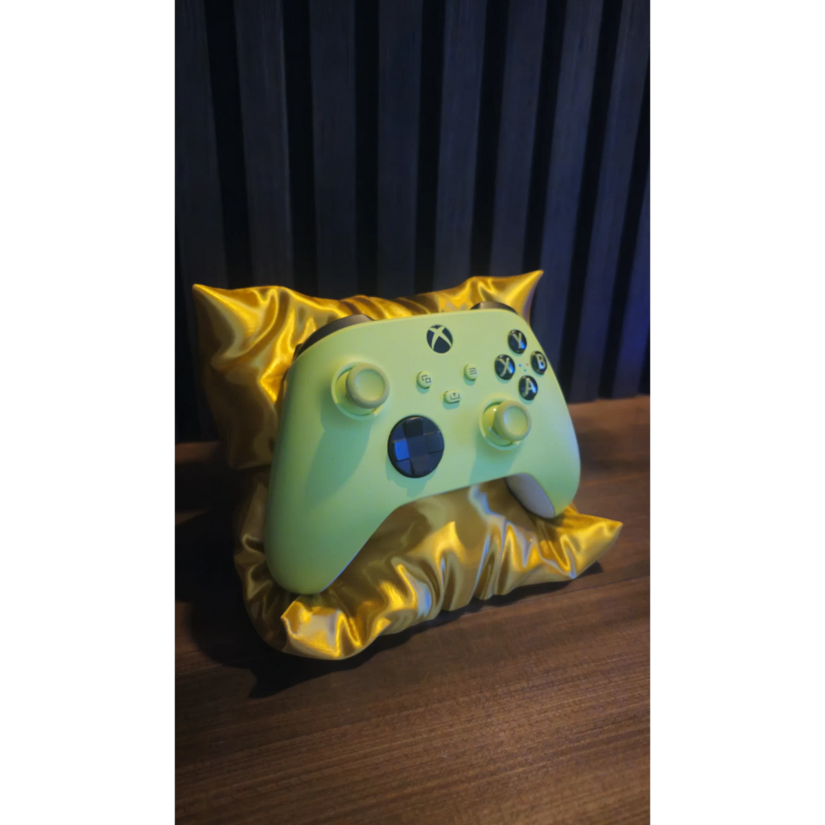 Magicland 3D lime green Xbox controller resting on a shiny gold satin pillow stand.