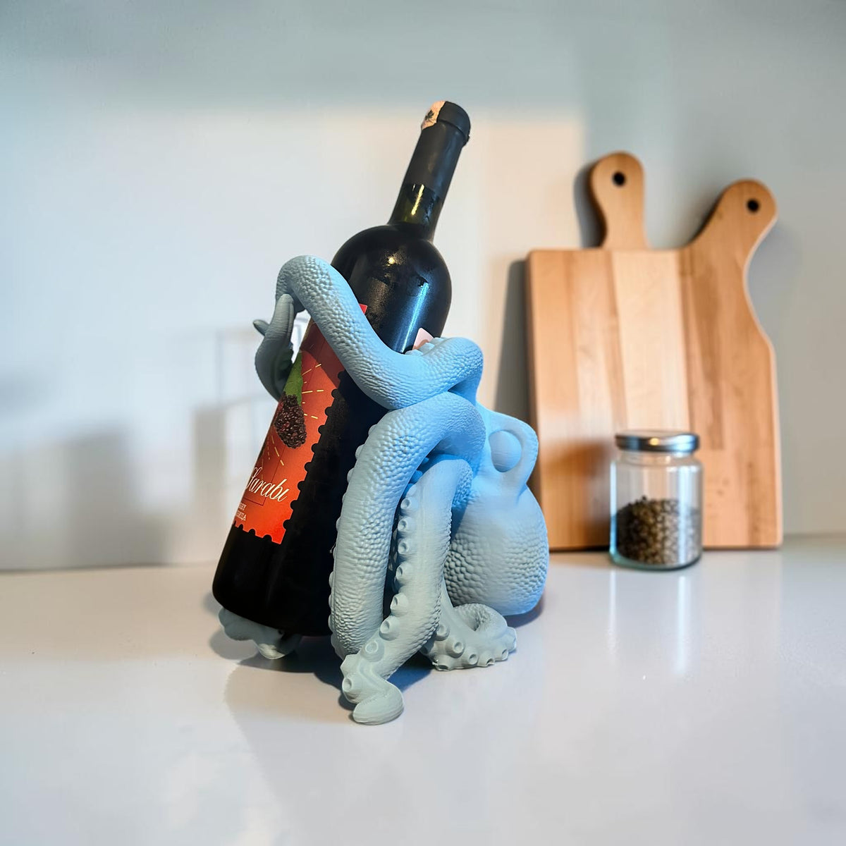 Light blue 3D printed octopus wine bottle holder by Magicland 3D, designed to grip a wine bottle with its tentacles.