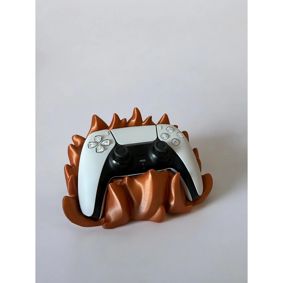 Magicland 3D flame-themed copper stand holding a white PS5 controller against a white background.