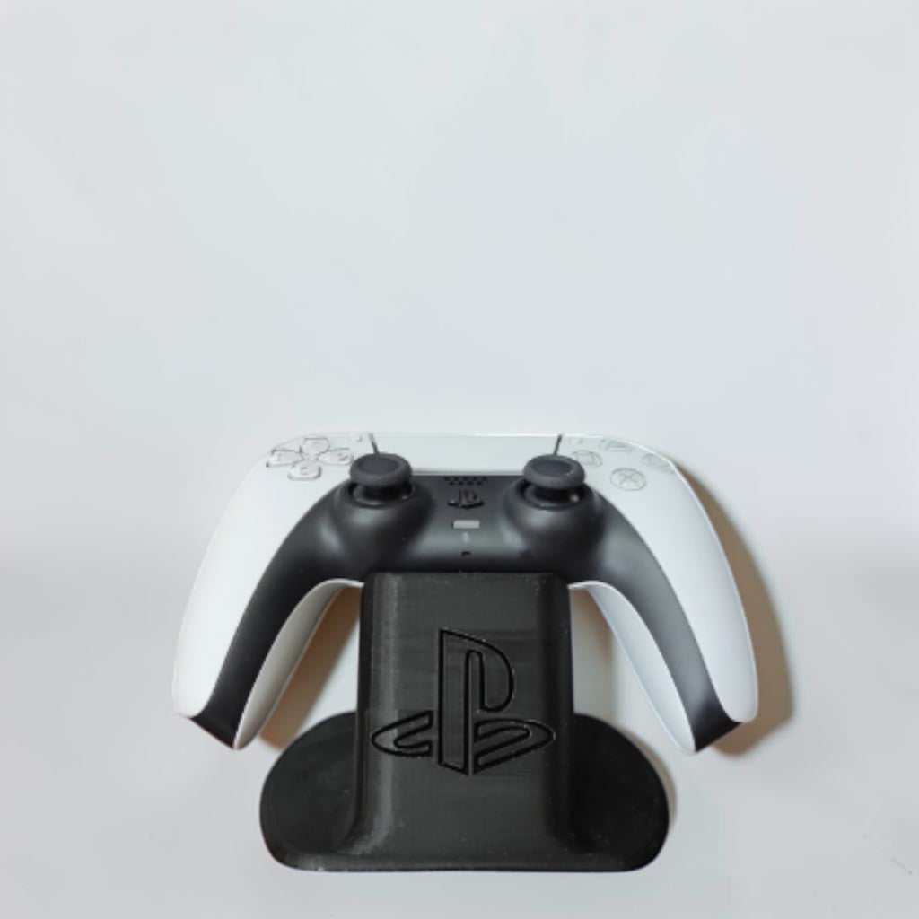 Magicland 3D black PS5 controller stand with PlayStation logo, holding a white PS5 controller.