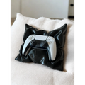 Magicland 3D black pillow-shaped stand holding a white PS5 controller on a textured cream cushion.