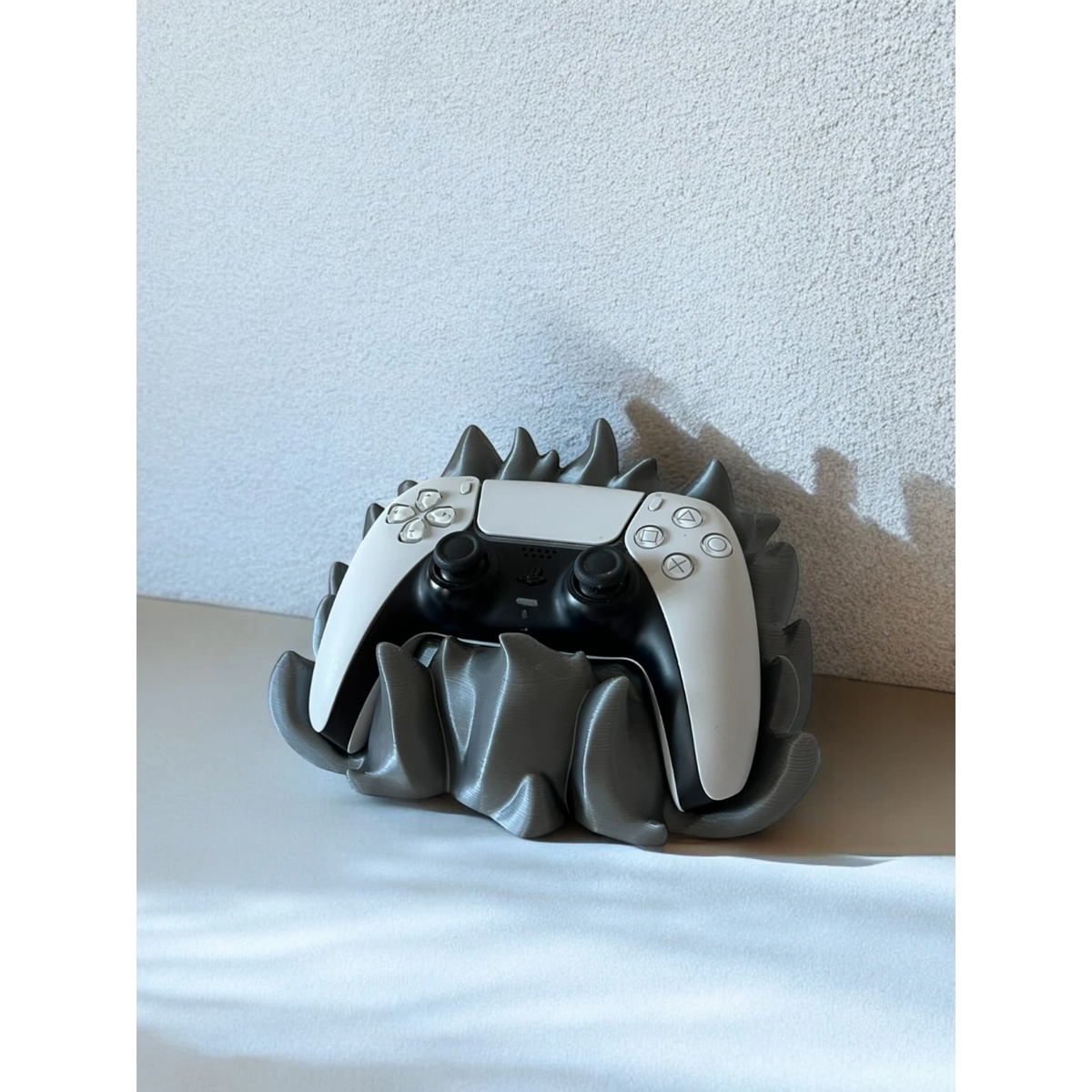 Magicland 3D grey flame-themed stand holding a white PlayStation 5 controller.