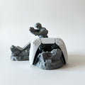 Magicland 3D Asker Figürlü Kol Standı, a grey soldier figure holding a gun, displays a white PS5 controller on a ruined base.