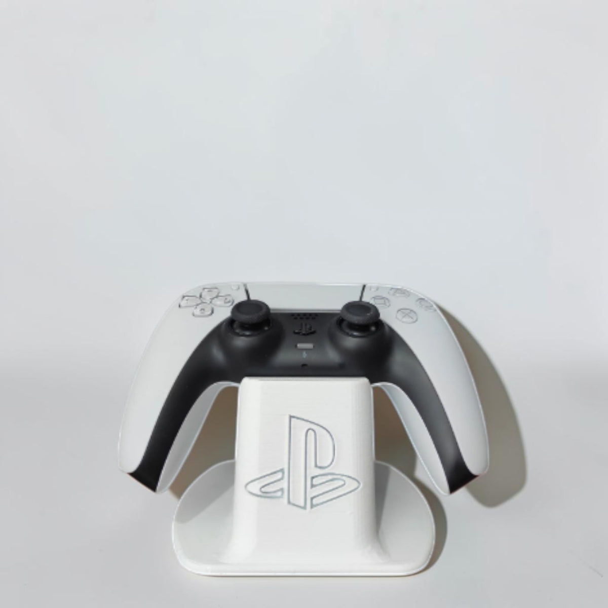 Magicland 3D white PS5 controller stand with PlayStation logo, holding a white PS5 controller.