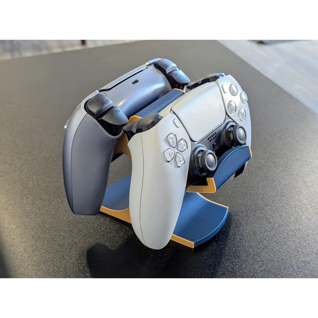 Magicland 3D PS5 dual controller stand in navy blue with gold trim, holding two controllers.