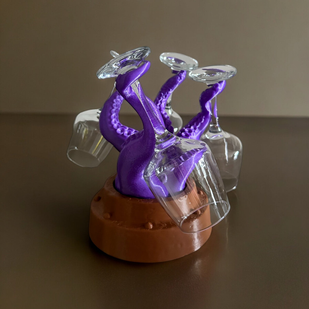 Magicland 3D purple octopus wine glass holder with brown base, holding four clear wine glasses.