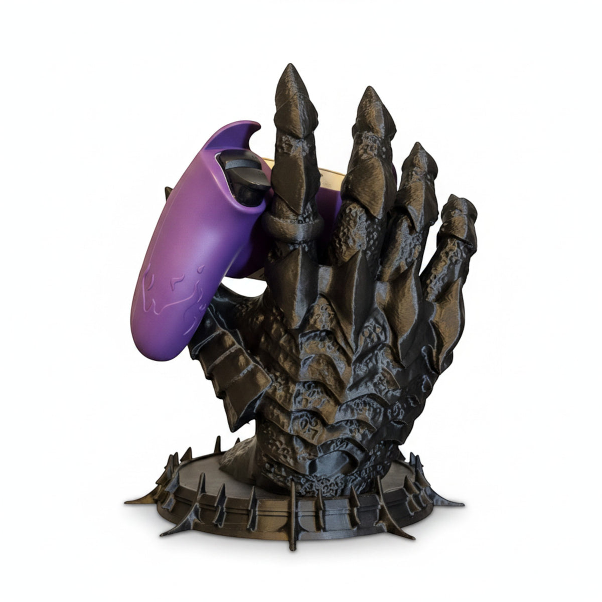 Magicland 3D'den Sauron'un elinden ilham alan siyah ejderha pençesi şeklinde oyun kumandası tutucu. Mor bir oyun kumandası tutuyor.