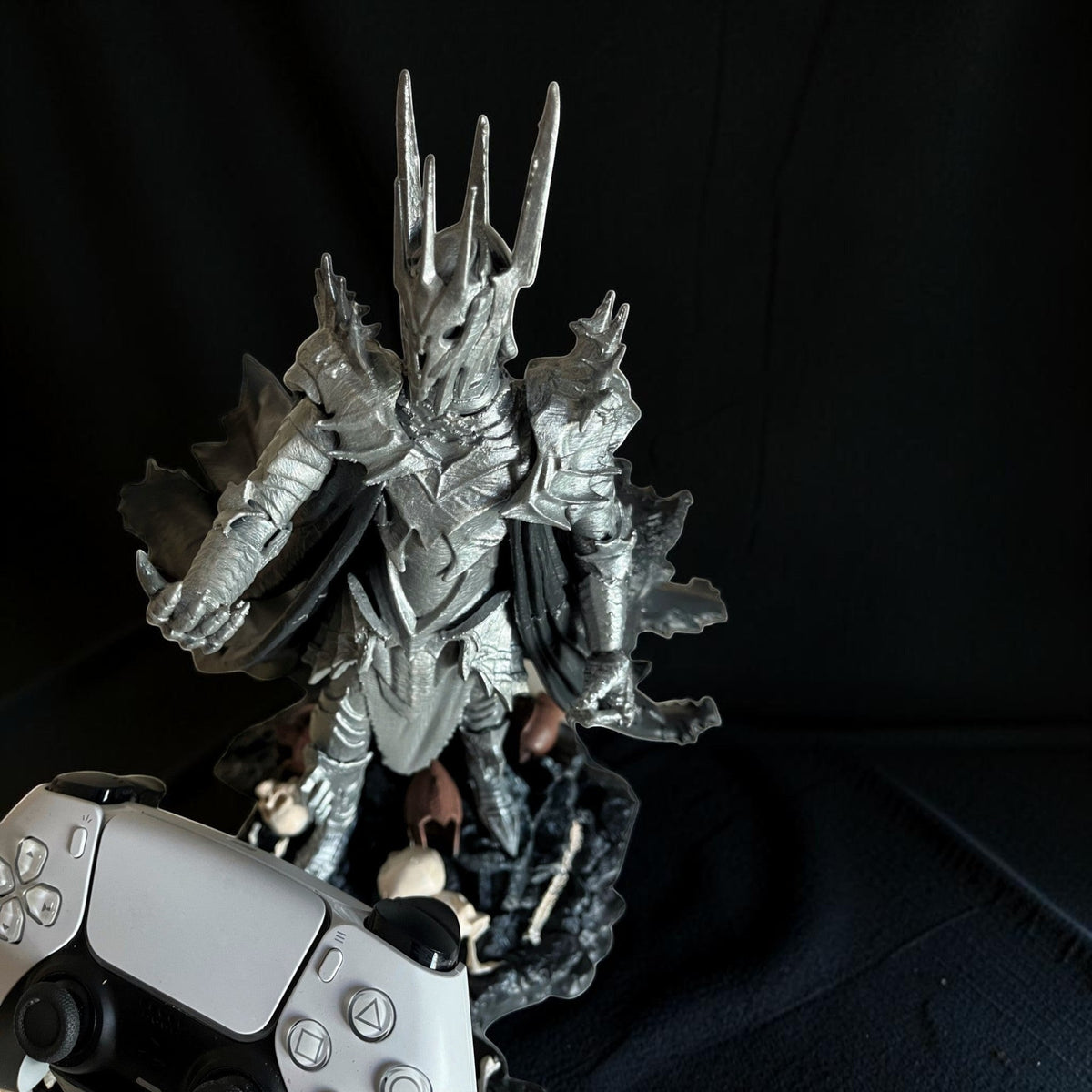Magicland 3D'den gümüş renkli, detaylı Sauron figürü, oyun kumandasıyla birlikte sergileniyor.