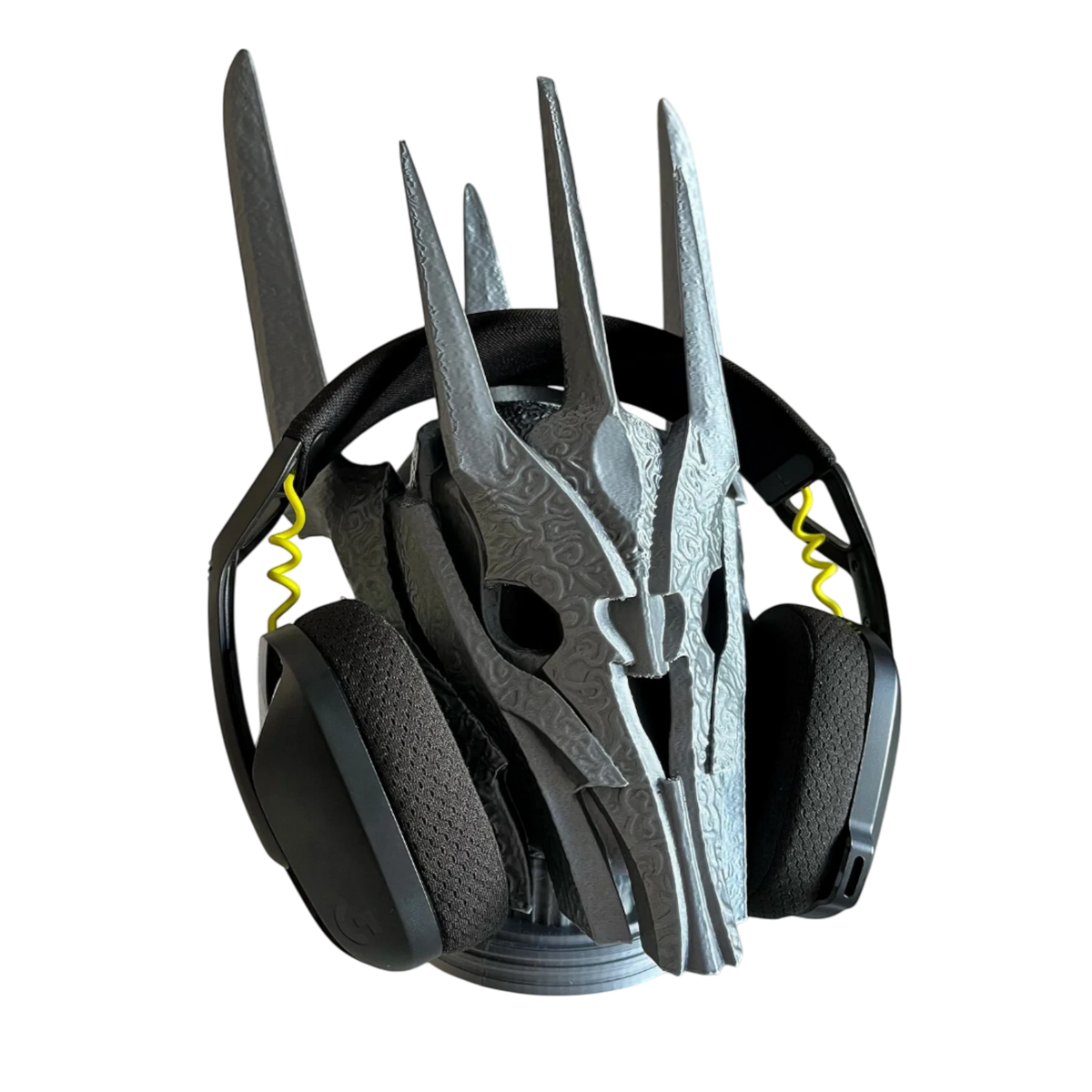 Magicland 3D Sauron desktop headphone stand, a grey, 3D-printed skull-shaped stand with intricate details, holding black headphones.