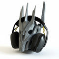 Magicland 3D Sauron desktop headphone stand, a silver, intricately carved helmet-shaped stand holding black headphones.