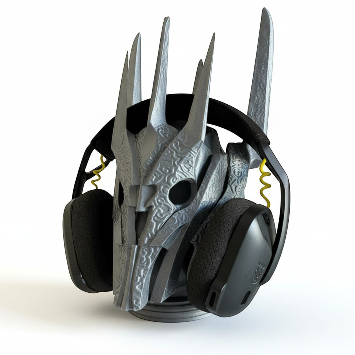 Magicland 3D Sauron desktop headphone stand, a silver, intricately carved helmet-shaped stand holding black headphones.