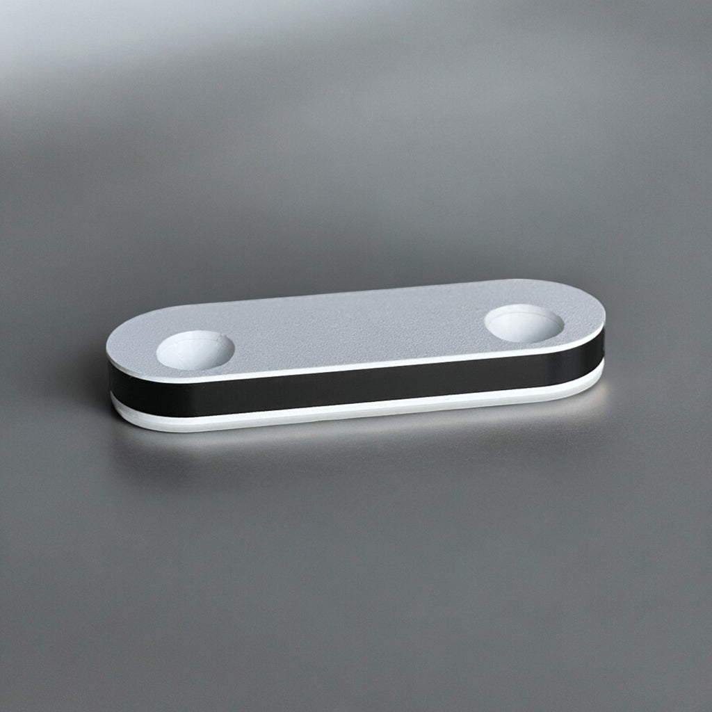 Magicland 3D minimalist silver phone stand with black and white trim, featuring two circular openings.