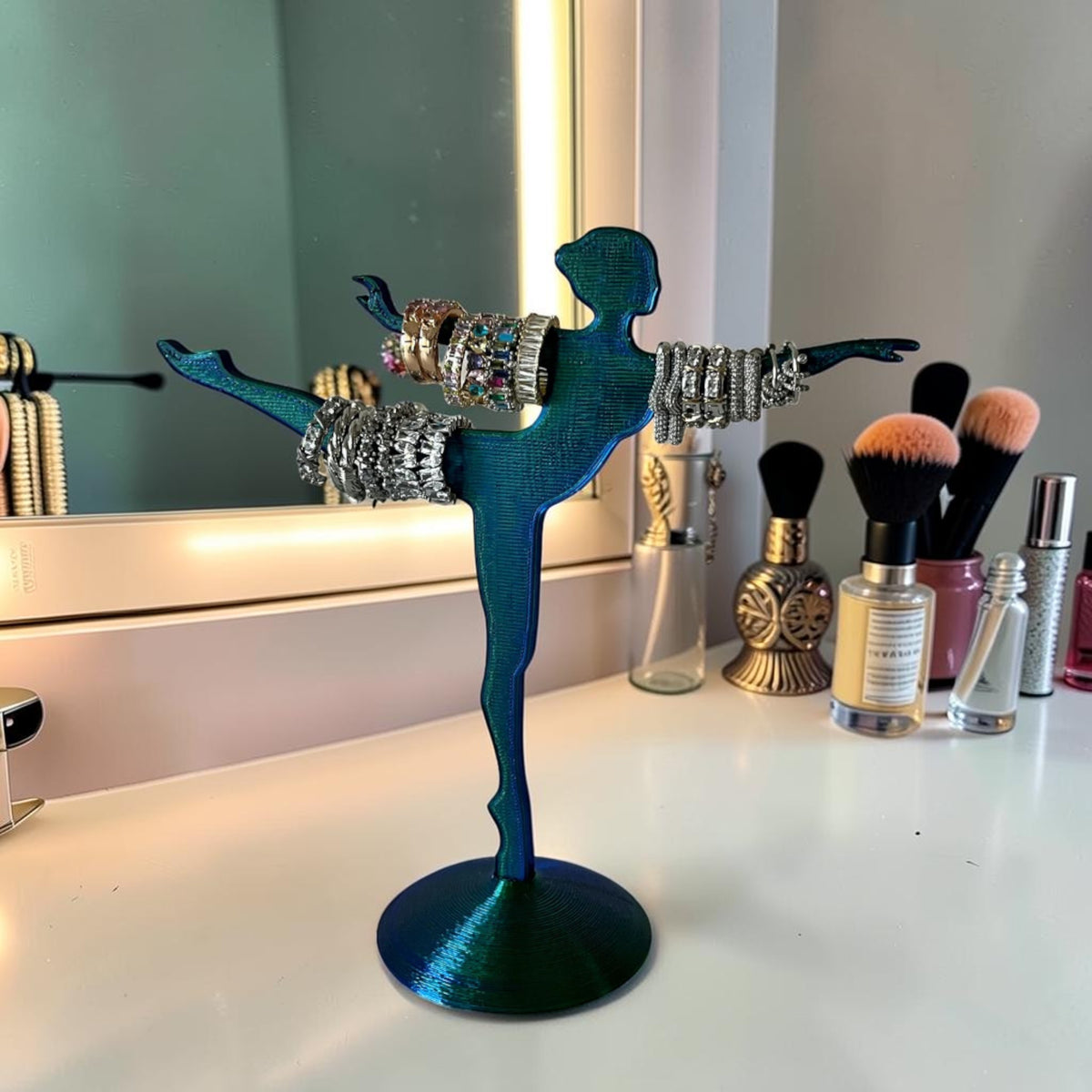Magicland 3D teal iridescent ballerina jewelry stand holding rings and bracelets. Decorative and functional.