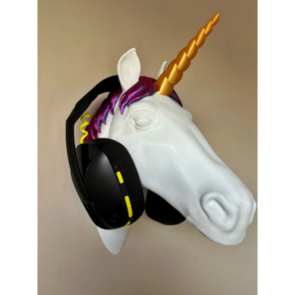 Magicland 3D white unicorn head headphone stand with gold horn and purple mane, holding black headphones.