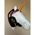 Magicland 3D white unicorn head headphone stand with gold horn and purple mane, holding black headphones.