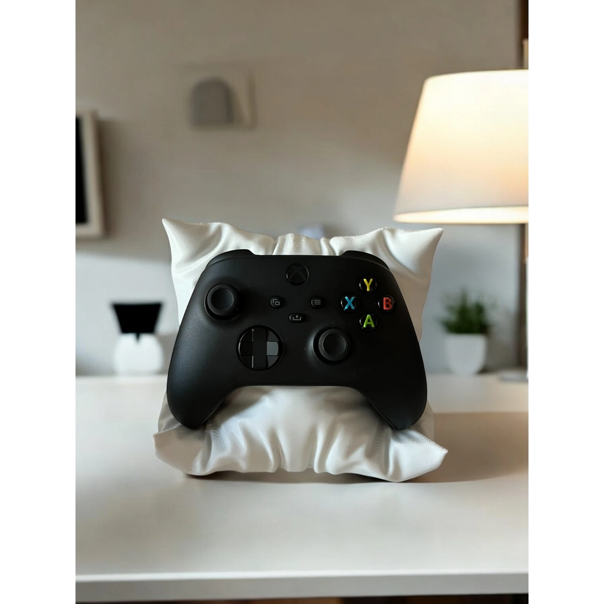 Magicland 3D white pillow-shaped stand holding a black Xbox controller on a white desk.