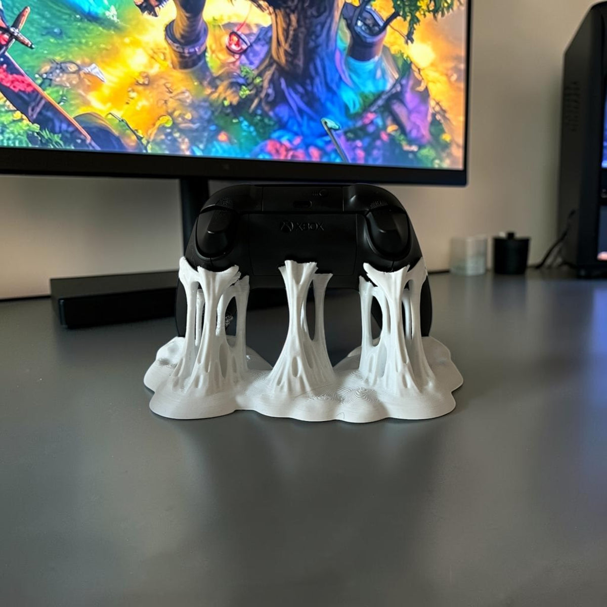 Magicland 3D white decorative stand with a dripping effect holding a black Xbox controller.