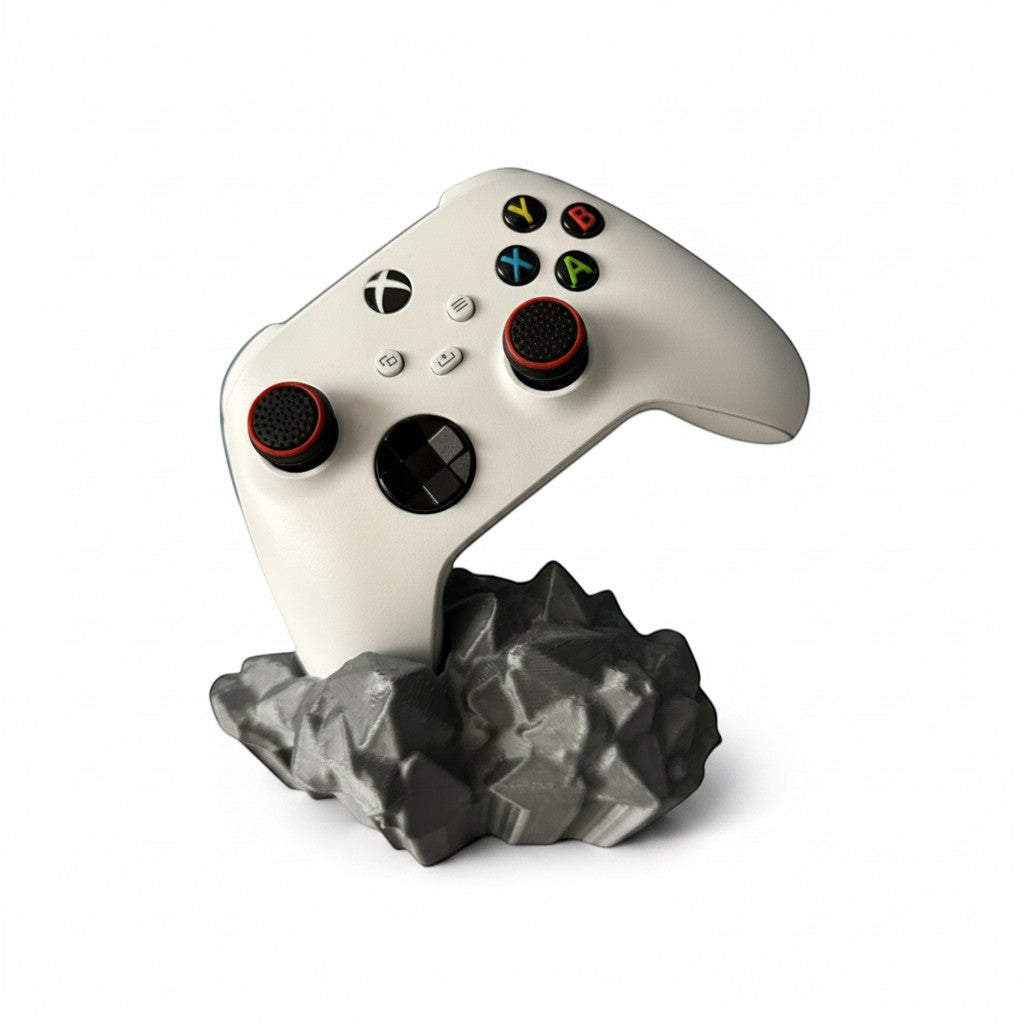 Magicland 3D white Xbox controller stand with a grey, rocky base. Features red and black accents on thumbsticks.
