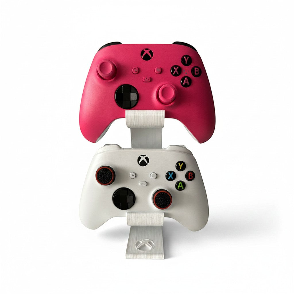 Magicland 3D vertical stand for two Xbox controllers, one pink and one white, with a brushed metal finish.