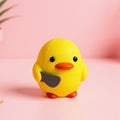 Magicland 3D yellow duck figurine with orange beak and feet, holding a small grey knife. Decorative desk accessory.