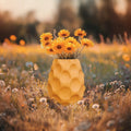 Magicland 3D yellow honeycomb textured decorative vase with yellow flowers in a meadow.